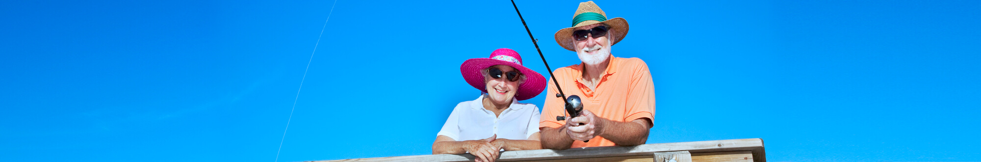 elderly couple wearing hat and sunglasses