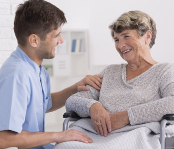 caregiver comforting elder woman on wheelchair